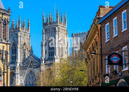 York, North Yorkshire / England: Imposing Gothic facade of York Minster with Thomas's of York pub with a sign on the right seen from Museum Street. Stock Photo