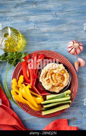 Top view of vivid platter of assorted fresh vegetables with hummus dip Stock Photo