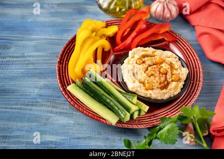 Bright platter of assorted fresh vegetables with hummus dip Stock Photo