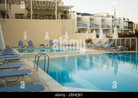 Early morning at the resort. The clear blue waters of the swimming pools await visitors Stock Photo