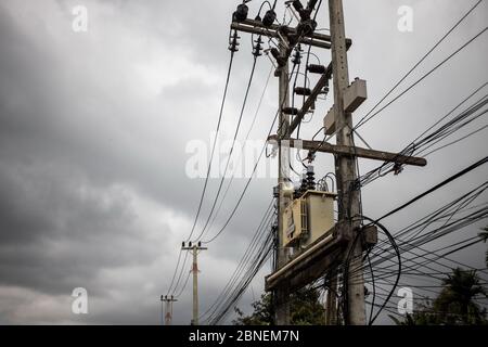 Wires attached to the electric pole, the chaos of cables and wires on an electric pole in asian street. concept of electricity Stock Photo