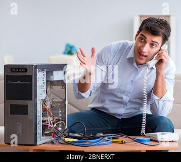 The angry customer trying to repair computer with phone support Stock Photo