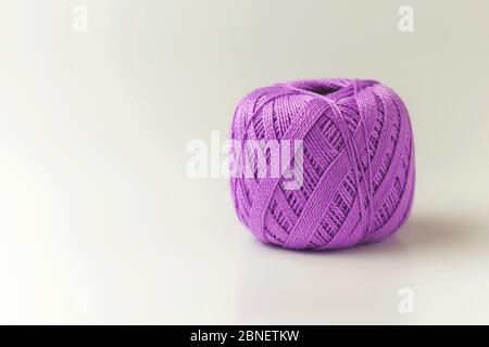 A skein of thread of purple color. Knitting threads on a white background. hobby. Stock Photo