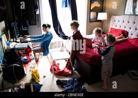 Four Siblings Hanging Out in Messy Teenage Brothers Bedroom Stock Photo