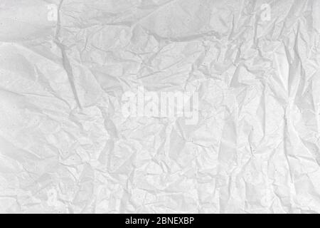 White wrinkled creased paper texture. Blank crumpled grainy paper textured surface. Smudged grungy grey poster. Close up. Material tissue for packing. Stock Photo