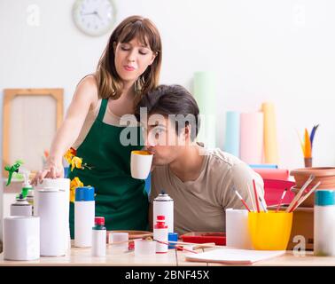 The couple decorating pots in workshop during class Stock Photo