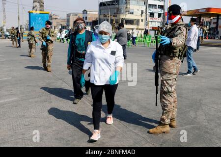 Lima, Peru. 14th May, 2020. A Peruvian soldier guard as market vendors wait in line for blood rapid diagnostic tests for the new coronavirus disease, COVID-19 at a market in Villa El Salvador Credit: Mariana Bazo/ZUMA Wire/Alamy Live News Stock Photo