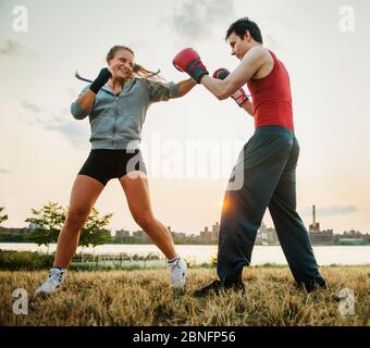 man and woman boxing, training in the park Stock Photo