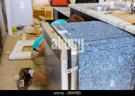 Plumber repair in the household dishwasher machine in kitchen Stock Photo