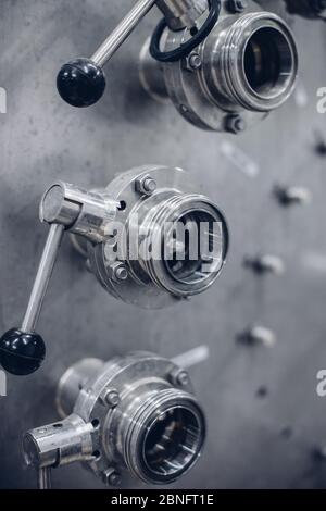 Vertical grayscale selective focus shot of stainless steel machine tools Stock Photo