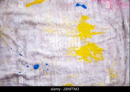 Closeup of a cloth with yellow and blue paint drops and splatters Stock Photo
