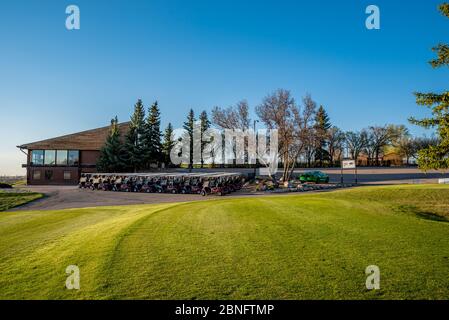 Swift Current, SK/Canada- May 14, 2020: Sunset over the first tee, carts and clubhouse at Elmwood Golf Course on the eve of their opening day Stock Photo