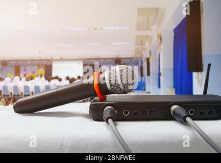 Close up old microphone wireless with box signal on the white table in business conference interior seminar meeting room and Background blur. Vintage Stock Photo