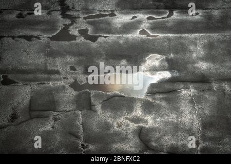 No people. Sky reflection in a puddle on the bad and cracked asphalt after the rain. Stock Photo
