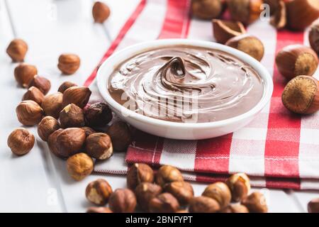 Sweet hazelnut spread. Chocolate cream in bowl on checkered napkin. Stock Photo