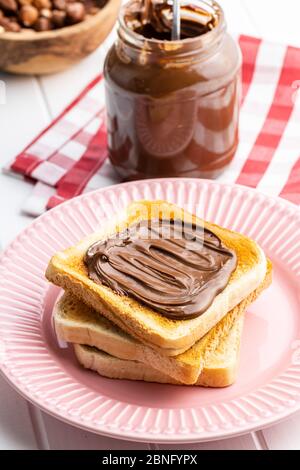 Toast bread with hazelnut spread on pink plate. Sweet chocolate cream. Stock Photo