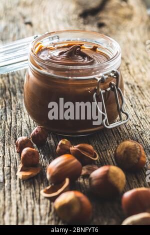 Sweet hazelnut spread. Chocolate cream in jar on old wooden table. Stock Photo