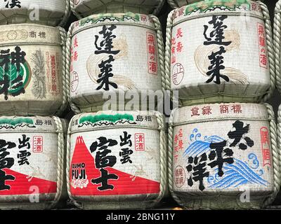 traditional Sake barrels at the entrance to Meiji  shrine in Tokyo.the writings in Japanese inform of the content of barrels and religious verses Stock Photo