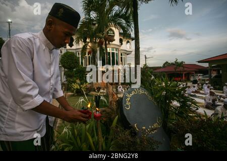 Kuala Lumpur, Malaysia. 14th May 2020. A staff (L) of Madrasah Darul Solihin Al Qadiri prepares the oil lamp outside Kuala Lumpur, Malaysia. 14th May, 2020. (issued 15 May 2020). Malaysia will partly ease the ban on mass prayers in most mosques starting 15 May, allowing a maximum of 30 people to gather for prayers ahead of Eid al-Fitr amid a drop in coronavirus cases. (Photo by Zulfadhli Zaki/Pacific Press) Credit: Pacific Press Agency/Alamy Live News Stock Photo