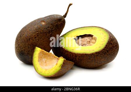 Fresh Avocados two whole and one halved isolated on white Stock Photo