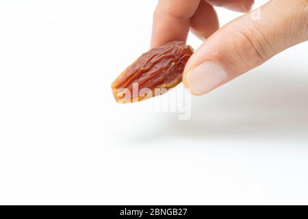 Hand holding  pitted dates isolated on white background Stock Photo