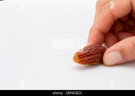 Hand holding  pitted dates isolated on white background Stock Photo