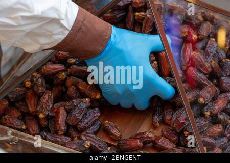 Seller hand holding  pitted dates. Close up Stock Photo