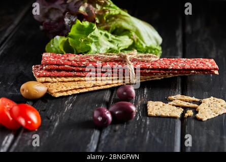 Beetroot and rye flour crackers with vegetables for making snacks on a black background. Vegetarianism and healthy eating Stock Photo