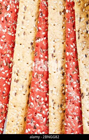 Beetroot and rye flour crackers with vegetables for making snacks on a wooden background. Vegetarianism and healthy eating Stock Photo
