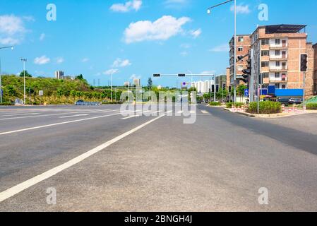Under the blue sky, there is no car asphalt road on the outskirts of town. Stock Photo