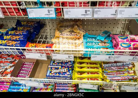 chocolate bars and sweets assortment displayed in open baskets at a supermarket in South Africa concept unhealthy junk food and snacks Stock Photo