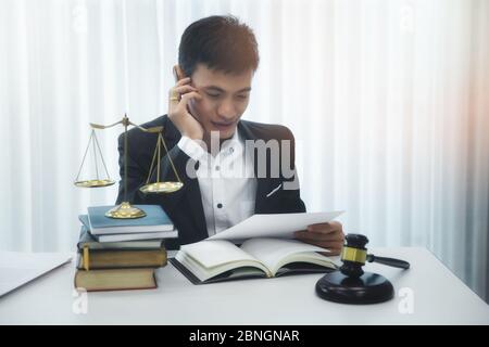 Asian male lawyer reading documents in his home office. Stock Photo