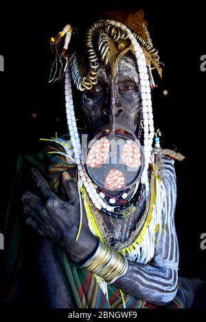 Mursi woman with large clay lip plate and headdress. Mago National Park. Omo Valley, Ethiopia. Stock Photo