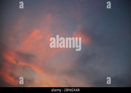 clearing of the last cloud. small clouds blown away by wind at sunset time. Purple and red vivid colorful soft light sky. twilight golden hour before Stock Photo
