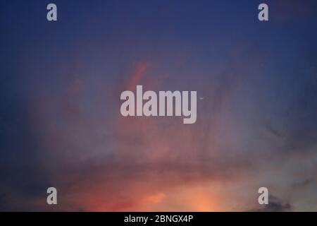 clearing of the last cloud. small clouds blown away by wind at sunset time. Purple and red vivid colorful soft light sky. twilight golden hour before Stock Photo