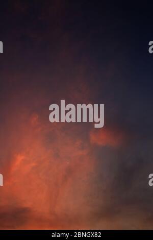 Burning sky, dramatic red colour clouds and sun ray shining through the heaven. God light and enigmatic powerful emotion. colour of nature. moody and Stock Photo