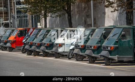 Piaggio Ape50 in a row  in Rome. Piaggio Ape is a three-wheeled light commercial vehicle first produced in 1948 by Piaggio Stock Photo