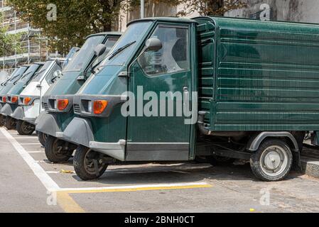 Piaggio Ape50 in a row  in Rome. Piaggio Ape is a three-wheeled light commercial vehicle first produced in 1948 by Piaggio Stock Photo