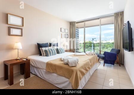 Modern bedroom with large glass windows. European hotel design. Stock Photo