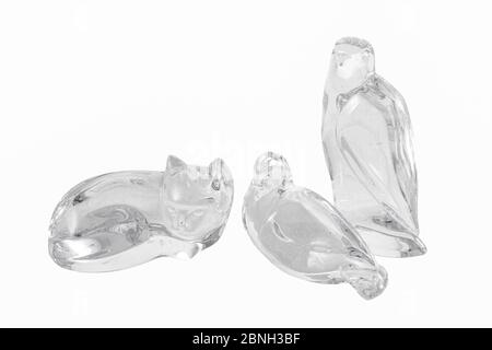 Closeup of owl and cat glass figures under the lights isolated on a white background Stock Photo