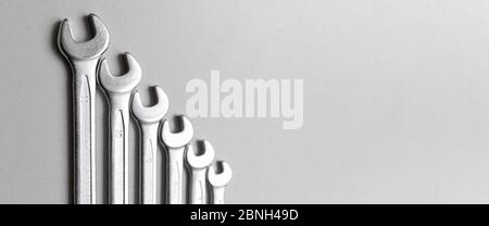 Spanners. Many wrenches. Grey background. Set of wrenches in different sizes on grey background.Banner. Stock Photo