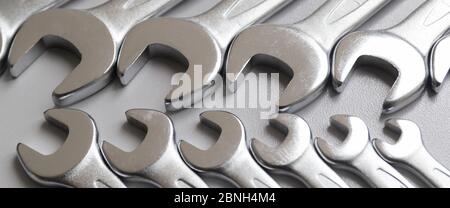Spanners. Many wrenches. Grey background. Set of wrenches in different sizes on grey background.Close up.Banner. Stock Photo