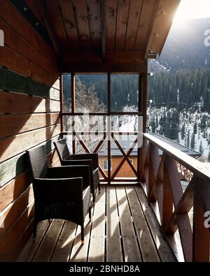 Terrace of wooden house with cozy chairs in the mountain resort at sunrise Stock Photo