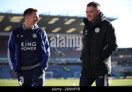 Leicester City First Team Player Liaison Officer talks with Leicester City's Marc Albrighton (left) during the Premier League match at Turf Moor, Burnley. Stock Photo