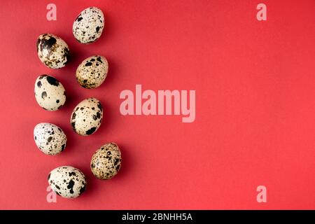 Creative quail egg layout on red background. Happy easter concept. Minimal design. Copy space, flat lay, from above Stock Photo