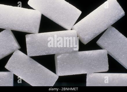 Closeup of white sugar cubes placed on each other with a black background Stock Photo