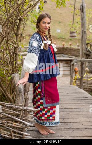 A girl in national dress is walking through an old bridge. Old