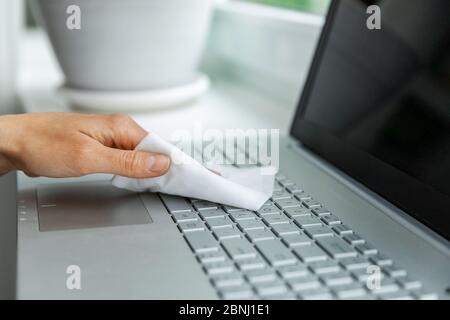 electronics disinfection and hygiene - hand cleaning laptop keyboard with antibacterial wet wipe Stock Photo