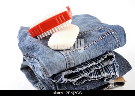 Jeans trousers with red brush and soap ready for cleaning Stock Photo