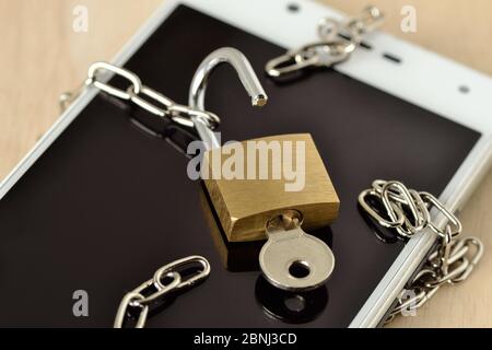 Open padlock with chain on mobile phone - Concept of phishing and security on mobile phones Stock Photo